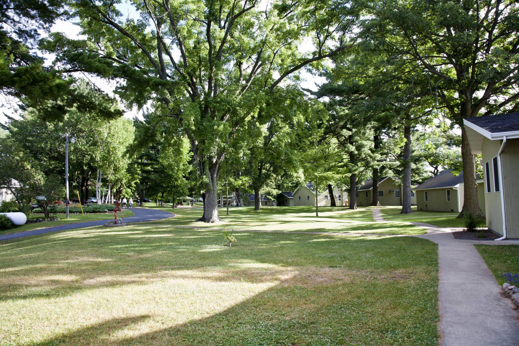 Green lawn and flower beds between the resort cottages